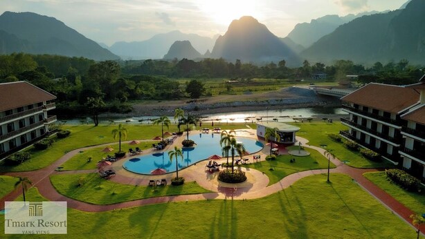 A resort with a large pool, multiple buildings, and a river. - Tmark Resort Vang Vieng (Vang Vieng)