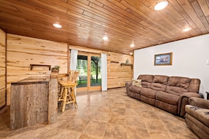 Un intérieur en bois avec un canapé en cuir marron, une table en bois et un banc.