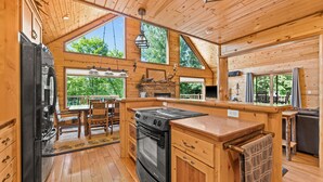 A spacious kitchen with wooden cabinets, a large stove, and a dining area with a table and chairs.