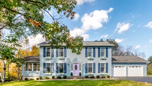 A two-story house with a front porch, a garage, and a well-maintained lawn.