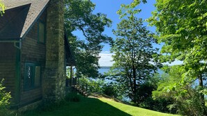 Ein Steinhaus mit Blick auf einen See und Bäume.