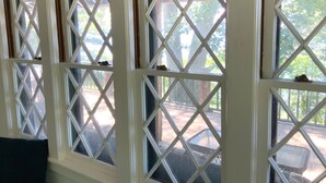 Ein Zimmer mit einem großen Fenster, dessen Scheiben ein Rautenmuster aufweisen.