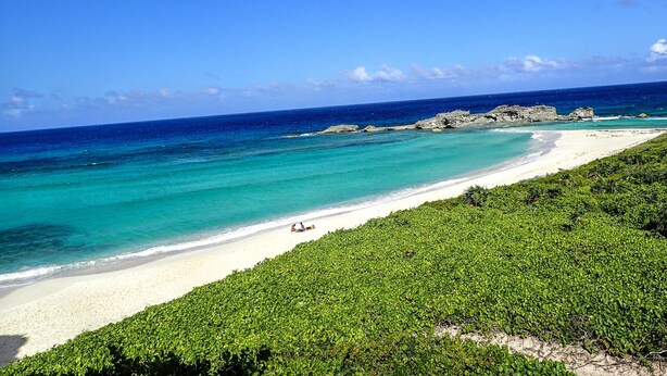 A beach with clear turquoise waters, white sand, and rocky outcrops. - Waterside Paradise! (Thompson Cove)