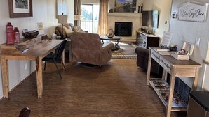 A cozy living room with a fireplace, a dining area, and a TV. - Johnny's Sedona Getaway - 2 Primary Suites 2 Bath (Sedona)