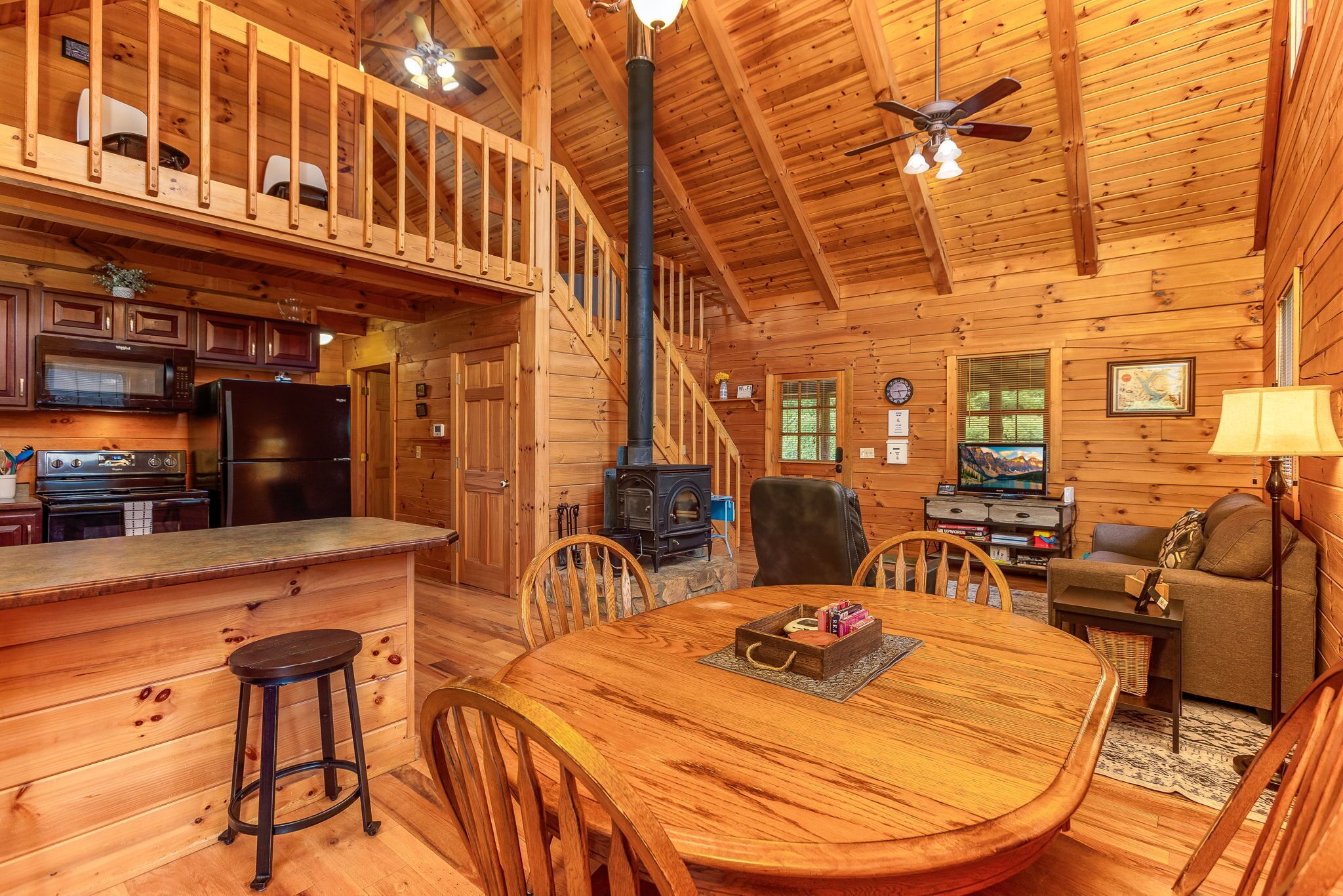 L’intérieur d’un chalet en bois comprend une cuisine, un coin repas et un salon.