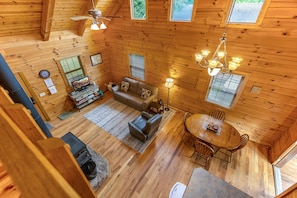 A cozy cabin interior with a living room, dining area, and a fireplace.