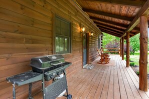 A wooden cabin with a covered porch, a grill, and outdoor seating. - White Pine - Cozy Cabin with Relaxing Hot Tub! (Nelsonville)
