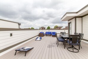 En takterrass med ett område för måltider, sittplatser och utsikt över de omgivande byggnaderna.