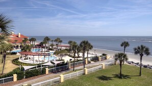 A resort with a pool, beach, and palm trees. - Wake up to the rhythm of the Atlantic. (St. Simons Island)