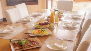 Un bufé de desayuno con diversos platos, entre ellos huevos revueltos, tocino y fruta.