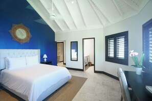 Habitación de hotel con una cama grande, un escritorio, una silla, un espejo y una ventana con persianas.