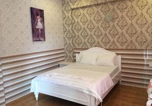 A bedroom with a bed, striped wall paneling, and a patterned wallpaper. - Khach San Dong Phuong (Ho Chi Minh City)