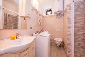 A modern bathroom with a sink, mirror, towel rack, and a shower area. - Casa Angerin 1 - 100m from sea, Alassio, Italy (Alassio)