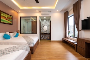A modern hotel room with two beds, a TV, a large window, and a shower area.