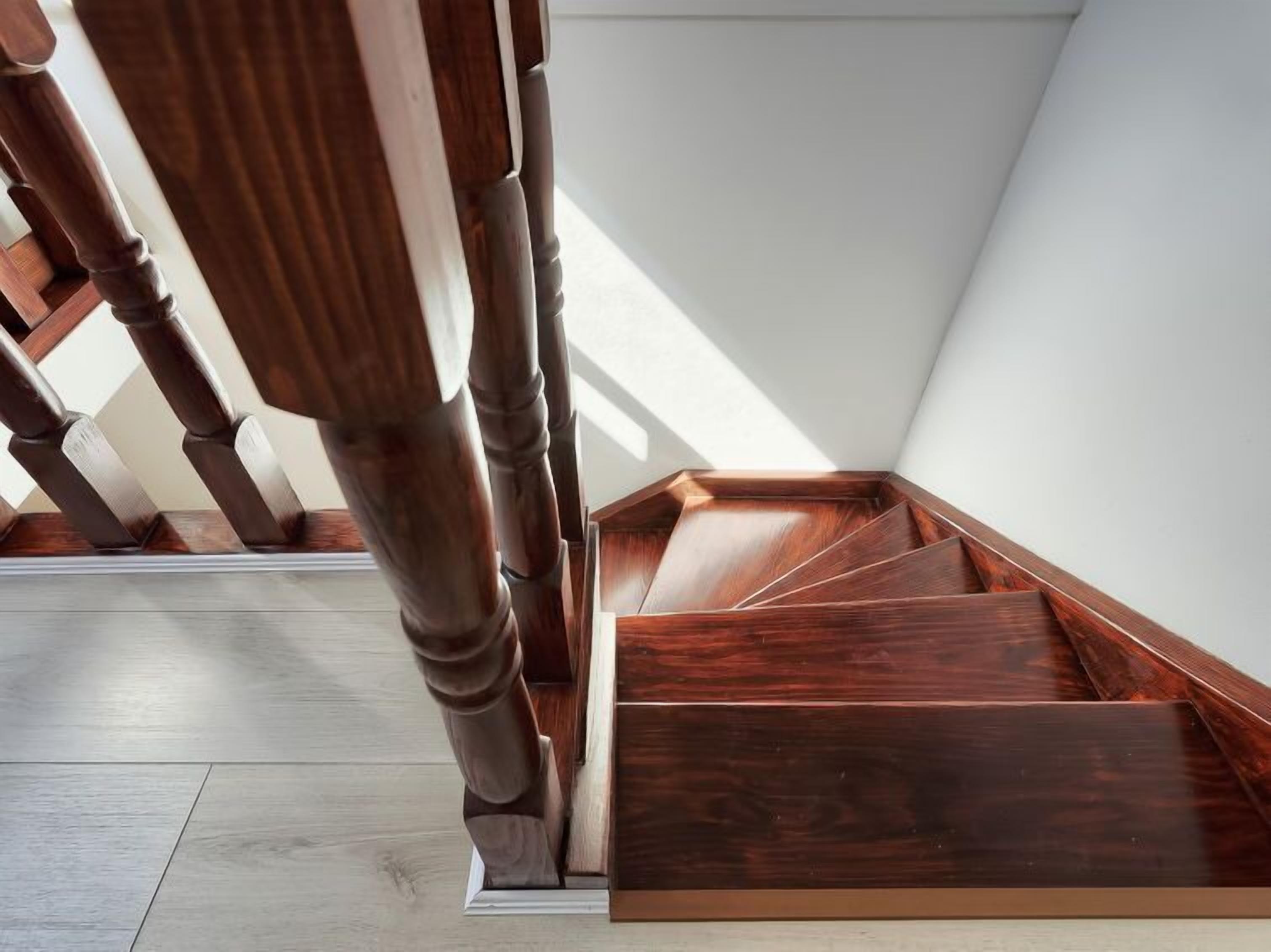 A wooden staircase with a modern design, leading to a higher floor.