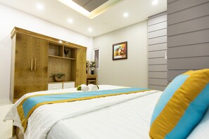 A modern bedroom with a bed, wooden wardrobe, and a painting on the wall.
