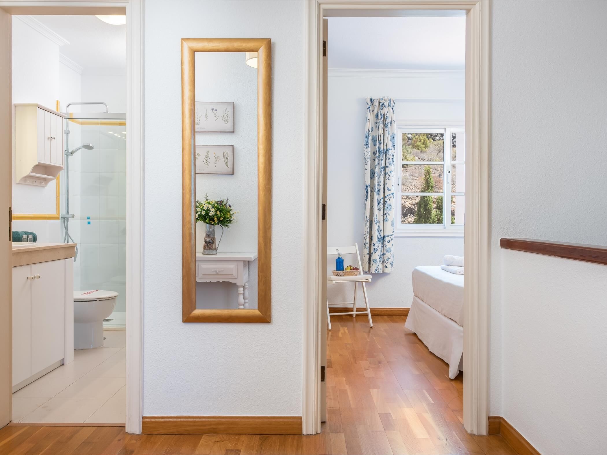 Une salle de bain moderne équipée d’une douche, de toilettes et d’un grand miroir.