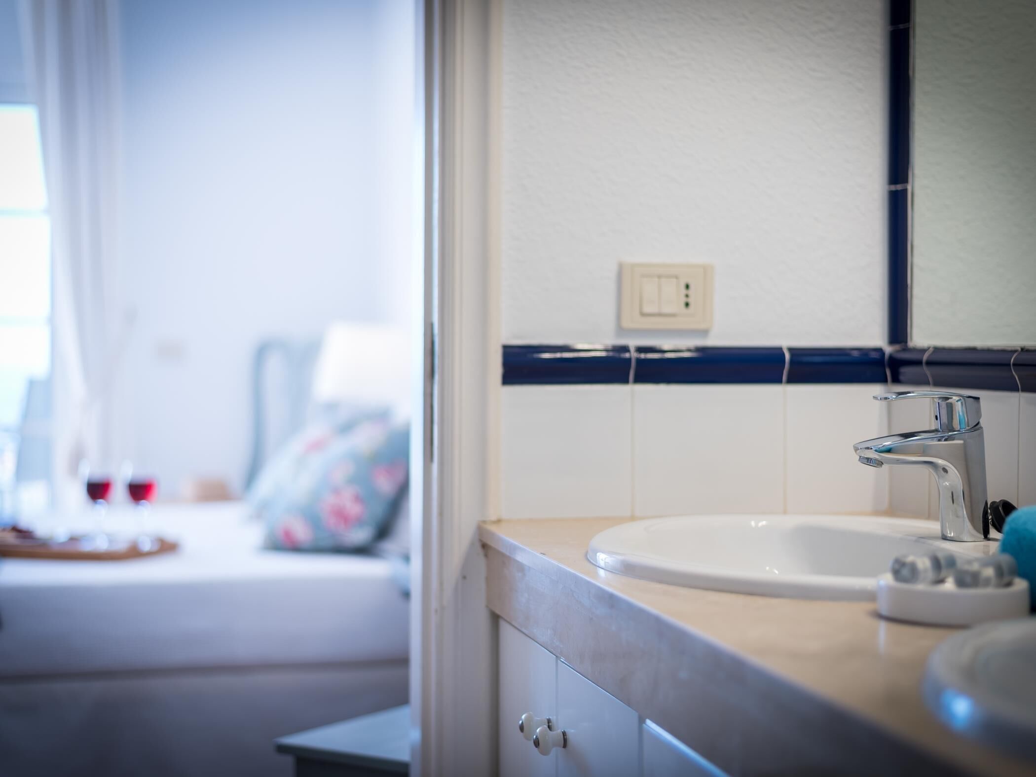 A bathroom with a white sink, a mirror, and a blue towel.