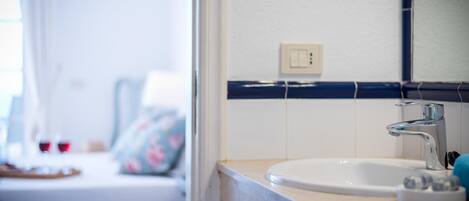 A bathroom with a white sink, a mirror, and a blue towel.