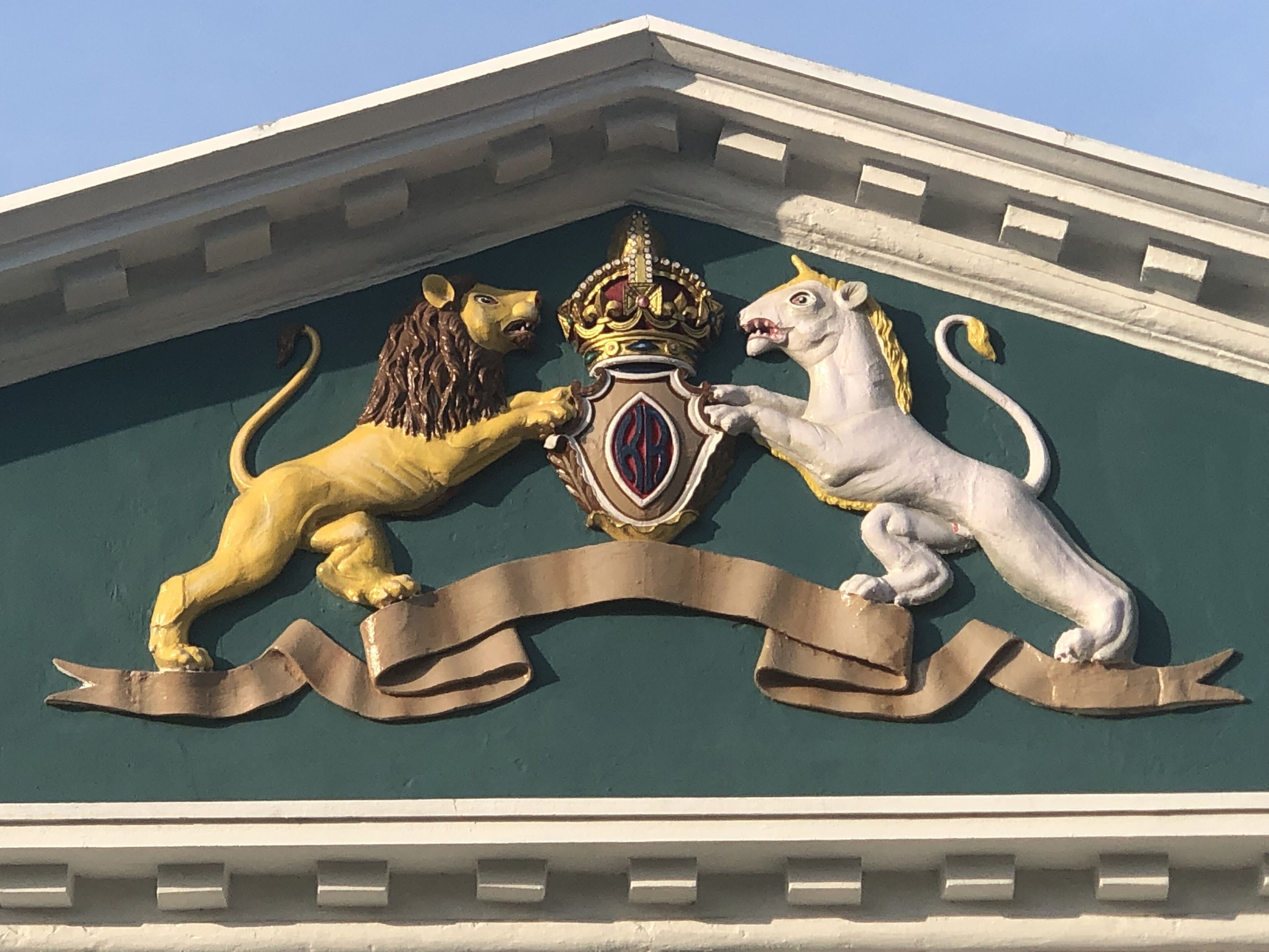 Une façade d’immeuble ornée d’une frise représentant deux lions et une couronne.