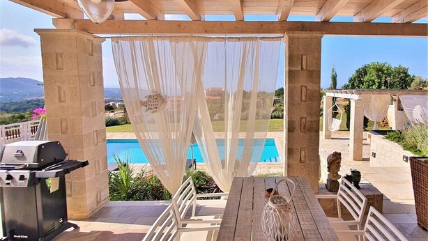 A covered outdoor patio with a pool, a grill, and a table with chairs. - Villa Dionysos, luxury villa with a fantastic view of a large plot of land (Rethymnon)