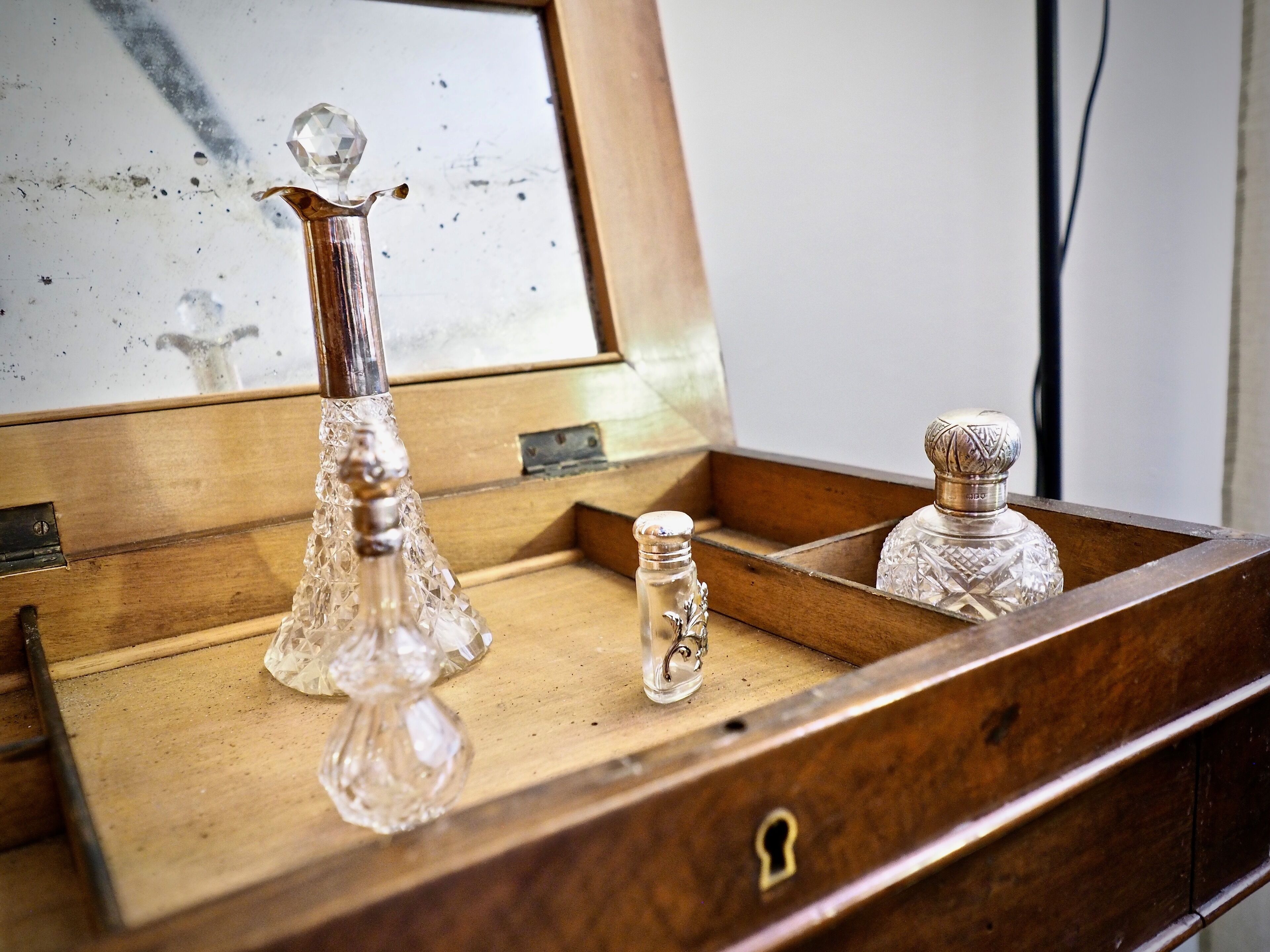 Une boîte en bois contenant trois carafes en verre.