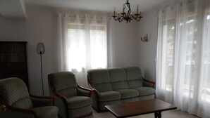 A living room with two armchairs, a sofa, a wooden coffee table, a floor lamp, and a chandelier. - Close to town center, many shops within walking distance (Revel)