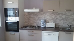 Eine Küche mit Einbauofen, Kaffeemaschine und Toaster.