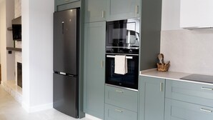 Una cocina moderna con refrigerador, horno y microondas incorporados.