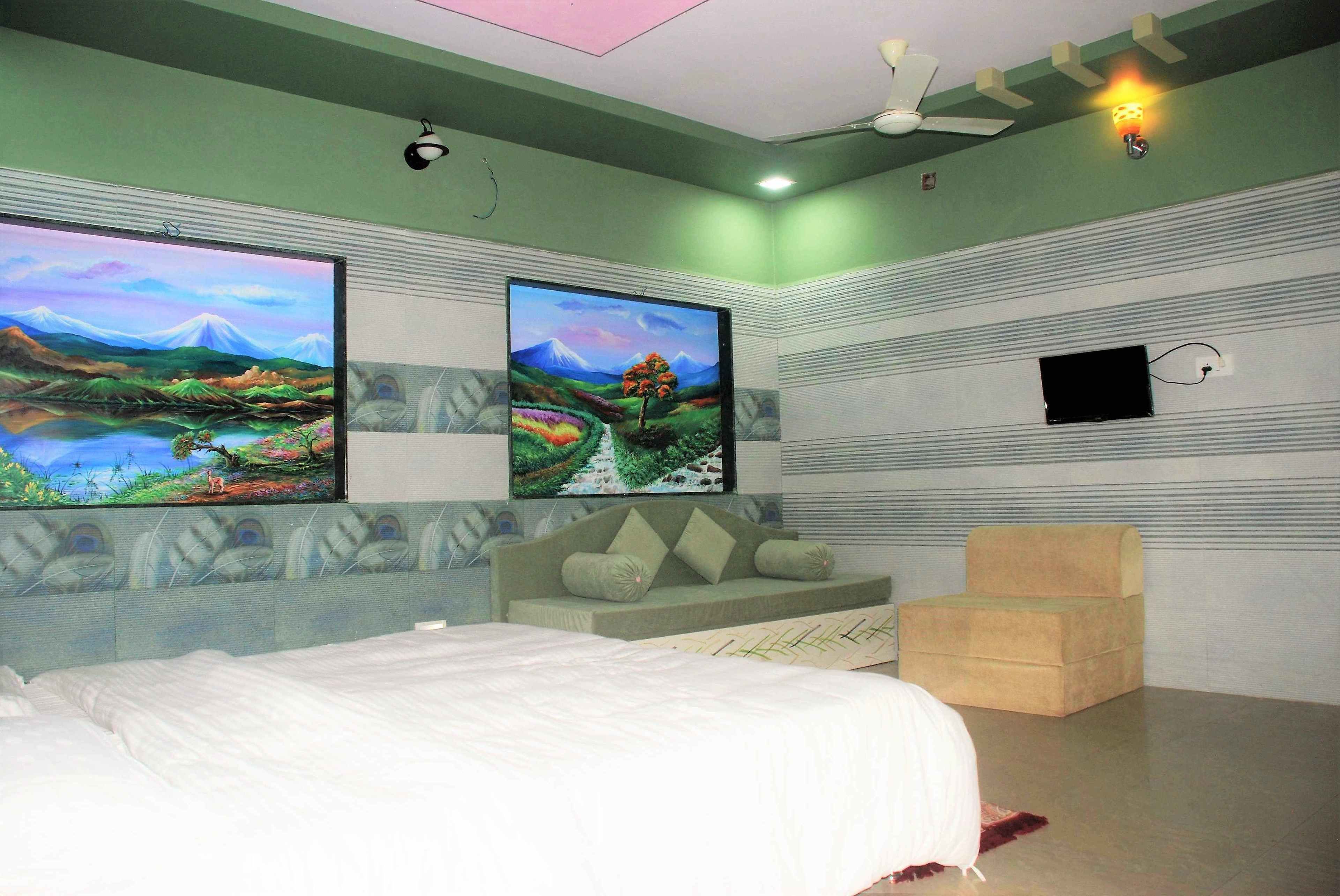 Une chambre à coucher avec un lit, un canapé, une télévision et un ventilateur de plafond.