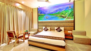 Quarto com uma cama grande, uma escrivaninha, uma cadeira e um quadro de uma paisagem na parede.