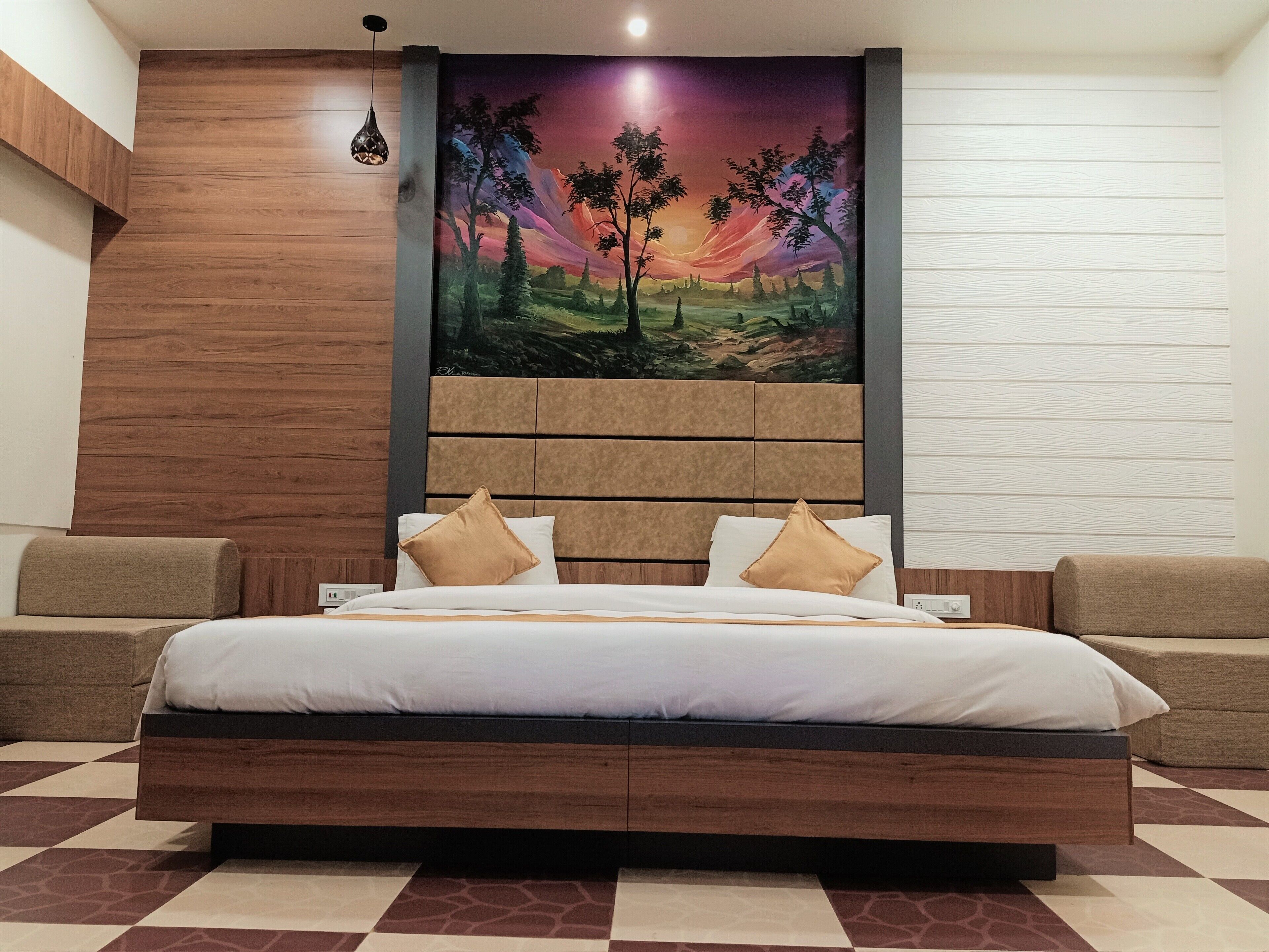 A bedroom with a large bed, wooden headboard, and a painting of a sunset landscape.