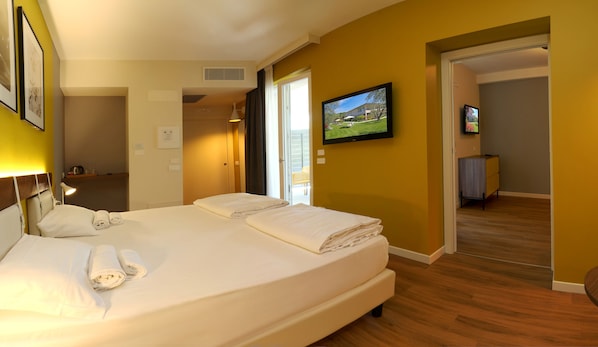 A hotel room with a bed, a TV, and a view of the outside. - Agriturismo La Rocca (Bardolino)