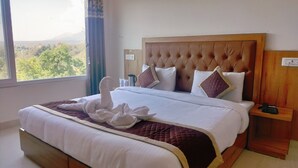 Une chambre d’hôtel avec un grand lit, une tête de lit en bois et une vue sur l’extérieur.