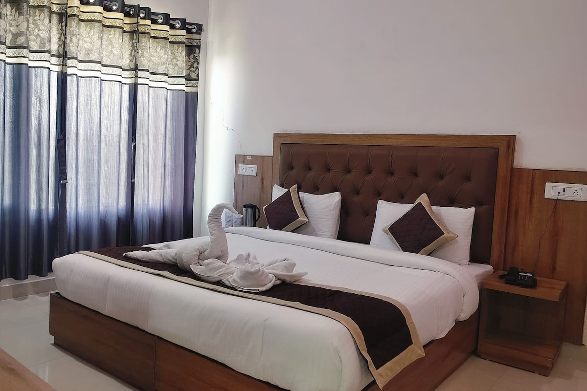 A neatly made bed with a brown headboard, white bedding, and decorative pillows.