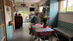 A kitchen with a dining area, a TV, and a window.