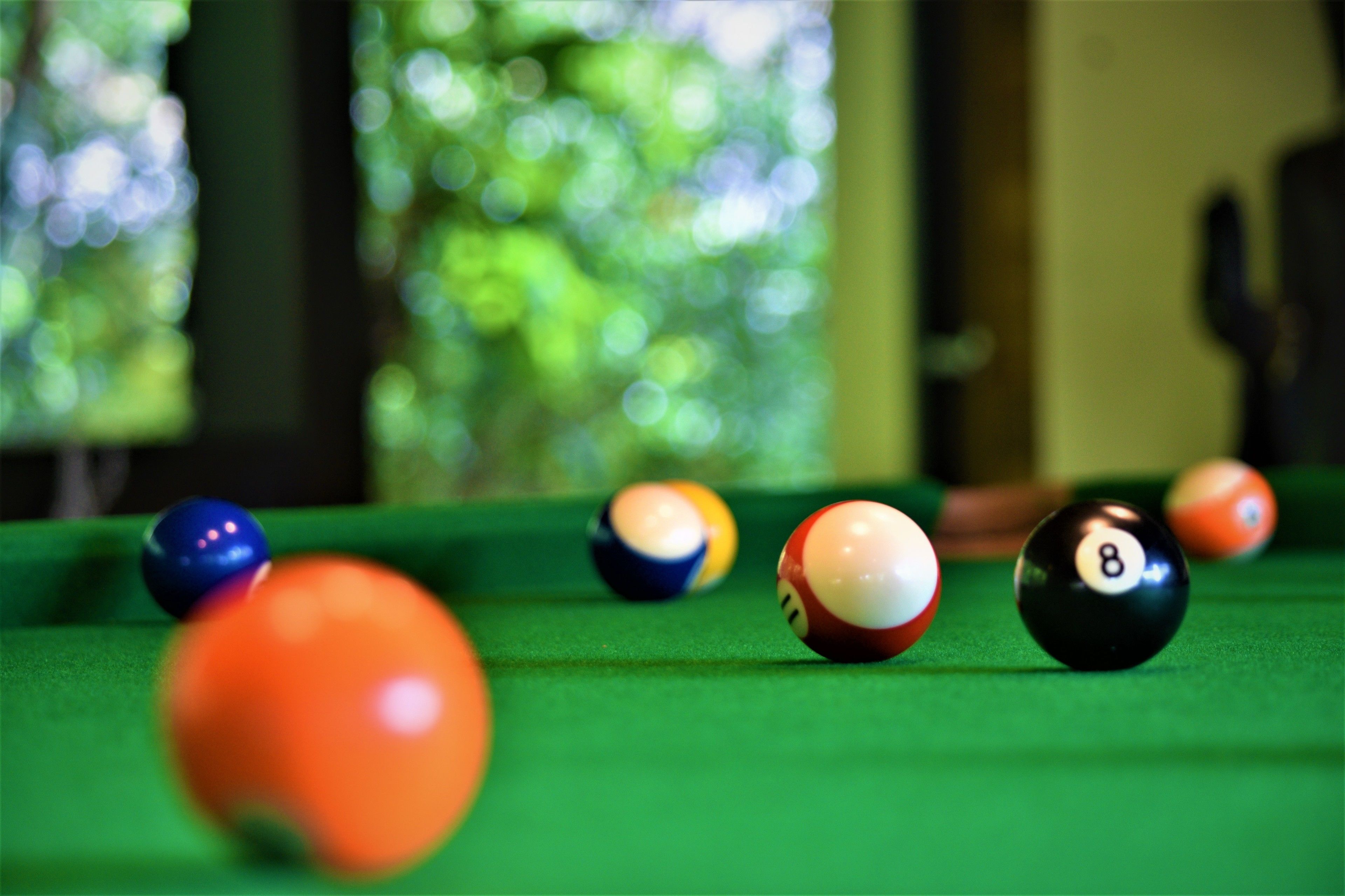 A close-up of a pool table with several billiard balls in focus.