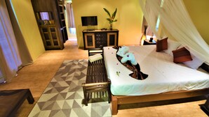 Un dormitorio con cama, mesita de noche y televisor sobre un mueble.
