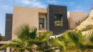 A modern building with a flat roof, a large window, and a stone facade. - Villa Sophia (Busot)