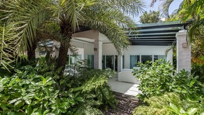 A modern house with a covered patio, surrounded by lush greenery and palm trees. - Perfect holiday home (Hua Hin)