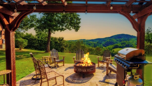 Un espace extérieur aménagé, abrité et doté d’un foyer, d’un coin barbecue et de fauteuils Adirondack.
