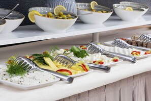A buffet table with various dishes and utensils.