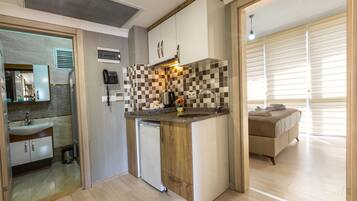 A compact kitchen with a built-in dishwasher, a coffee maker, and a small countertop.