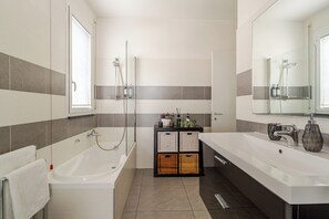 Een bad/douchecombinatie, een haardroger, een bidet, handdoeken