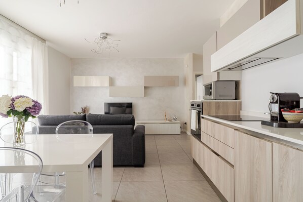 A modern kitchen with a dining area, a sofa, and a TV. - Dalmine Luxury Suite 10 minutes from Bergamo  (Dalmine)
