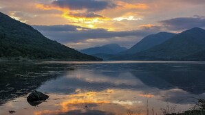 A calm lake with mountains in the background and a cloudy sky. - The Old Byre at Dallachulish. (Oban)