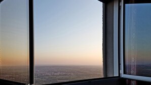 Une grande fenêtre donnant sur un paysage urbain, avec une vue dégagée pendant la journée.