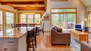 A spacious living area with a wooden ceiling, large windows, a dining area, and a cozy seating arrangement. - Manchester,  Mt Equinox Views, Hot Tub, Horse-show,golf,skiing,hiking,fishing (Sunderland)