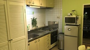 A compact kitchen with a gas stove, a microwave, and a refrigerator. - only 2 stops to SHIBUYA, free pocket wifi provided (世田谷区)