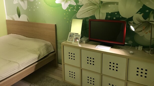 A bedroom with a bed, a desk with a computer monitor, and a wall with floral wallpaper. - only 2 stops to SHIBUYA, free pocket wifi provided (世田谷区)